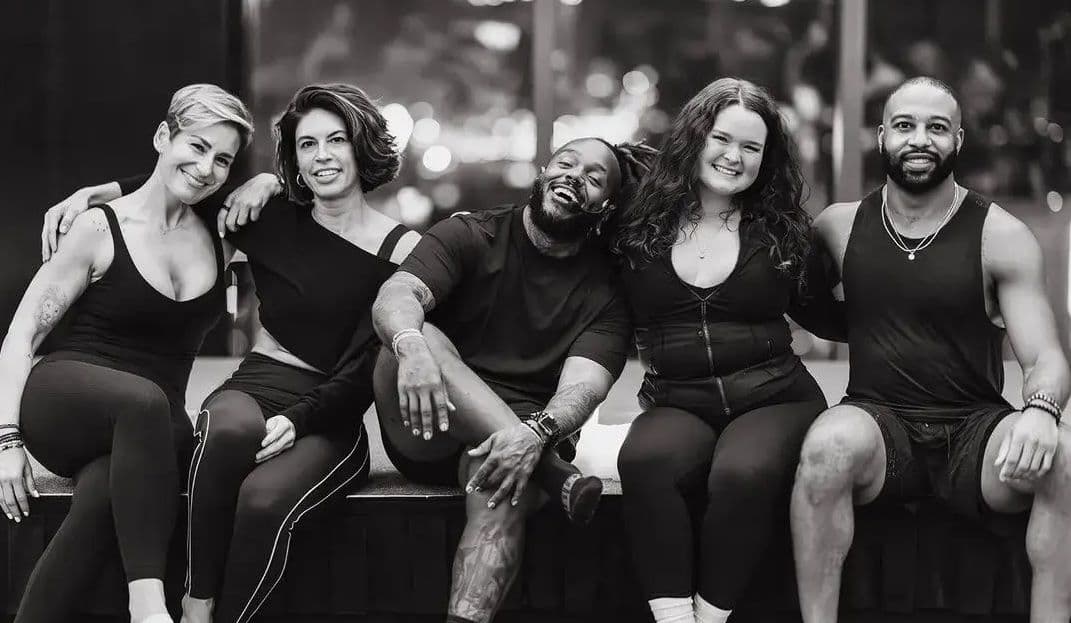 Dynamic group portrait of a high-performance fitness team, highlighting strength, discipline, and team spirit in an energetic training environment.